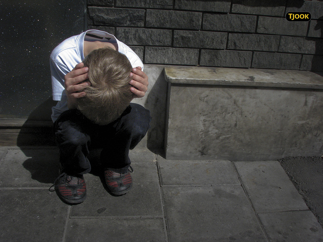 A young boy huddled down in despair