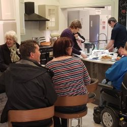 Photo of people sat enjoying tea and cake