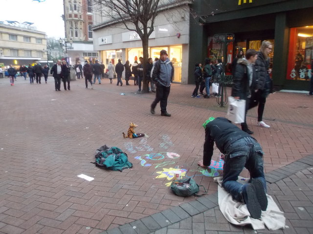 Photo: Homeless man chalks art on the pavement. "Homeless art beats begging".