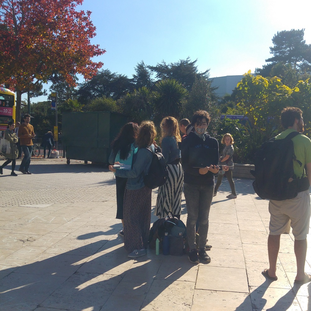 Small group holding laptops in Bournemouth Square