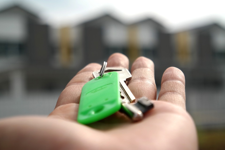 keys in hand and houses in the background