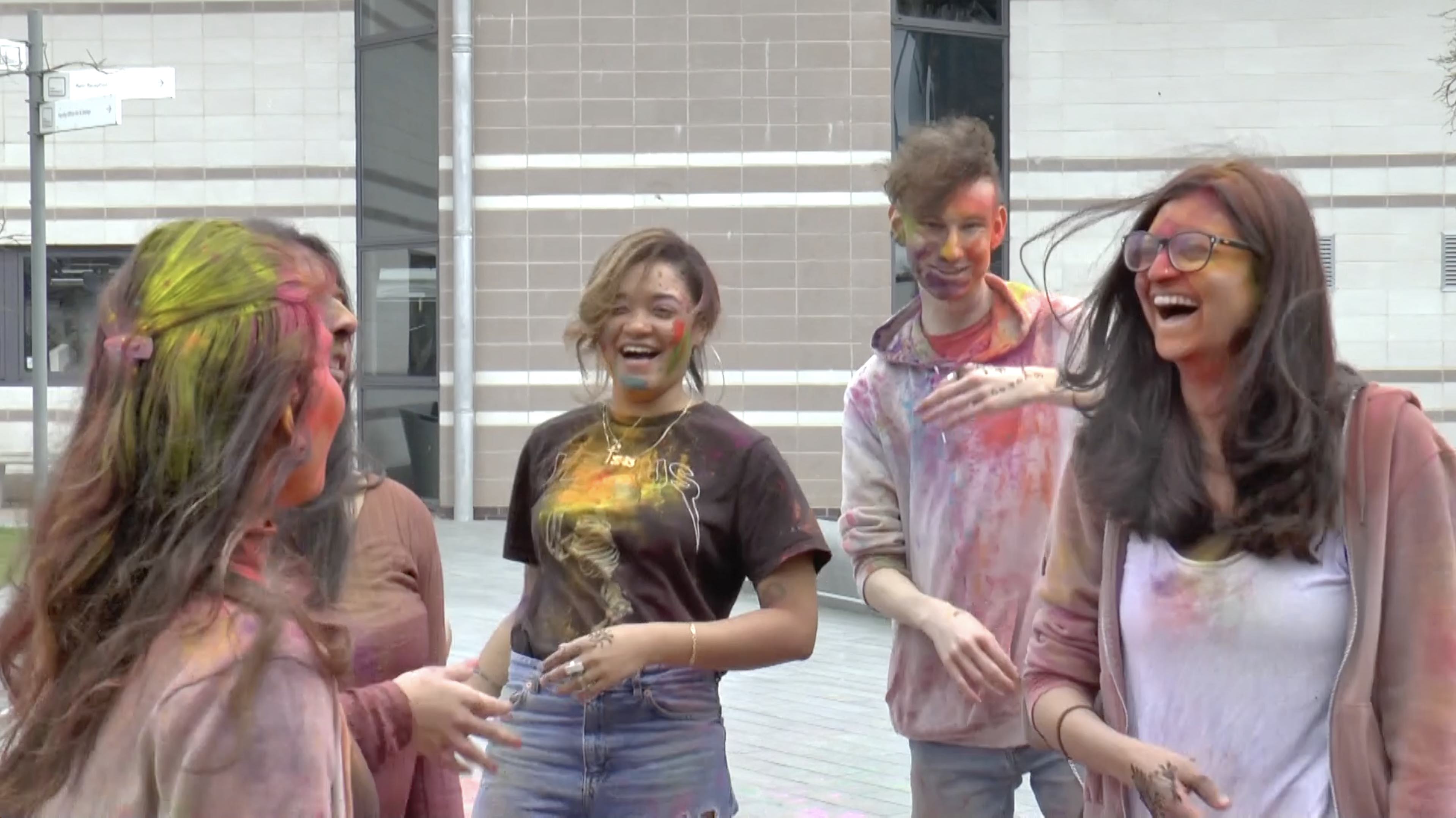 people laughing covered in colours