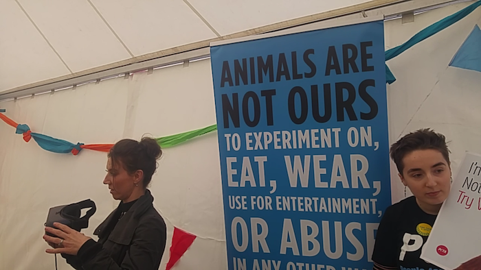 two activists promoting veganism, holding placard