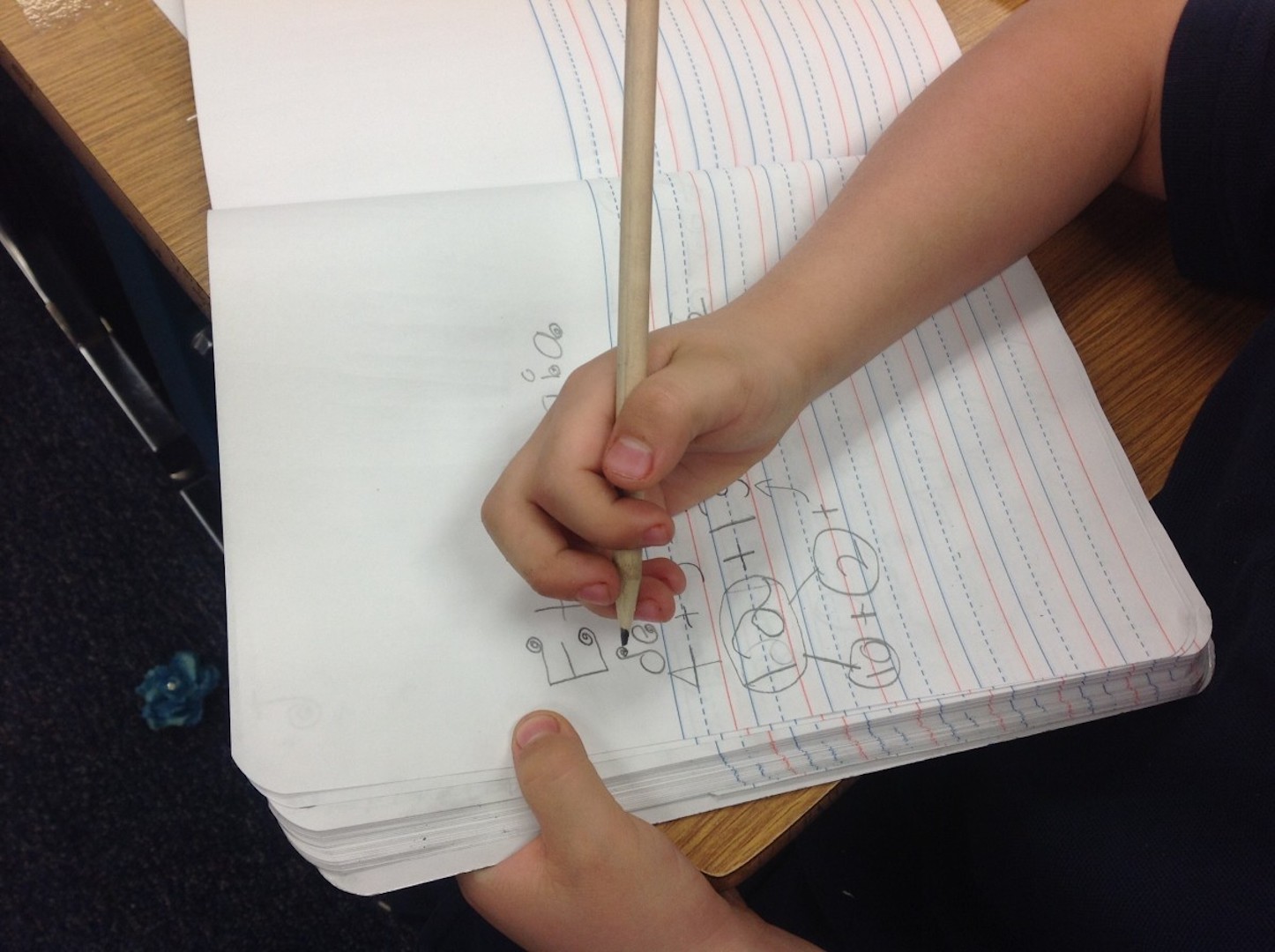 Child writing in school book