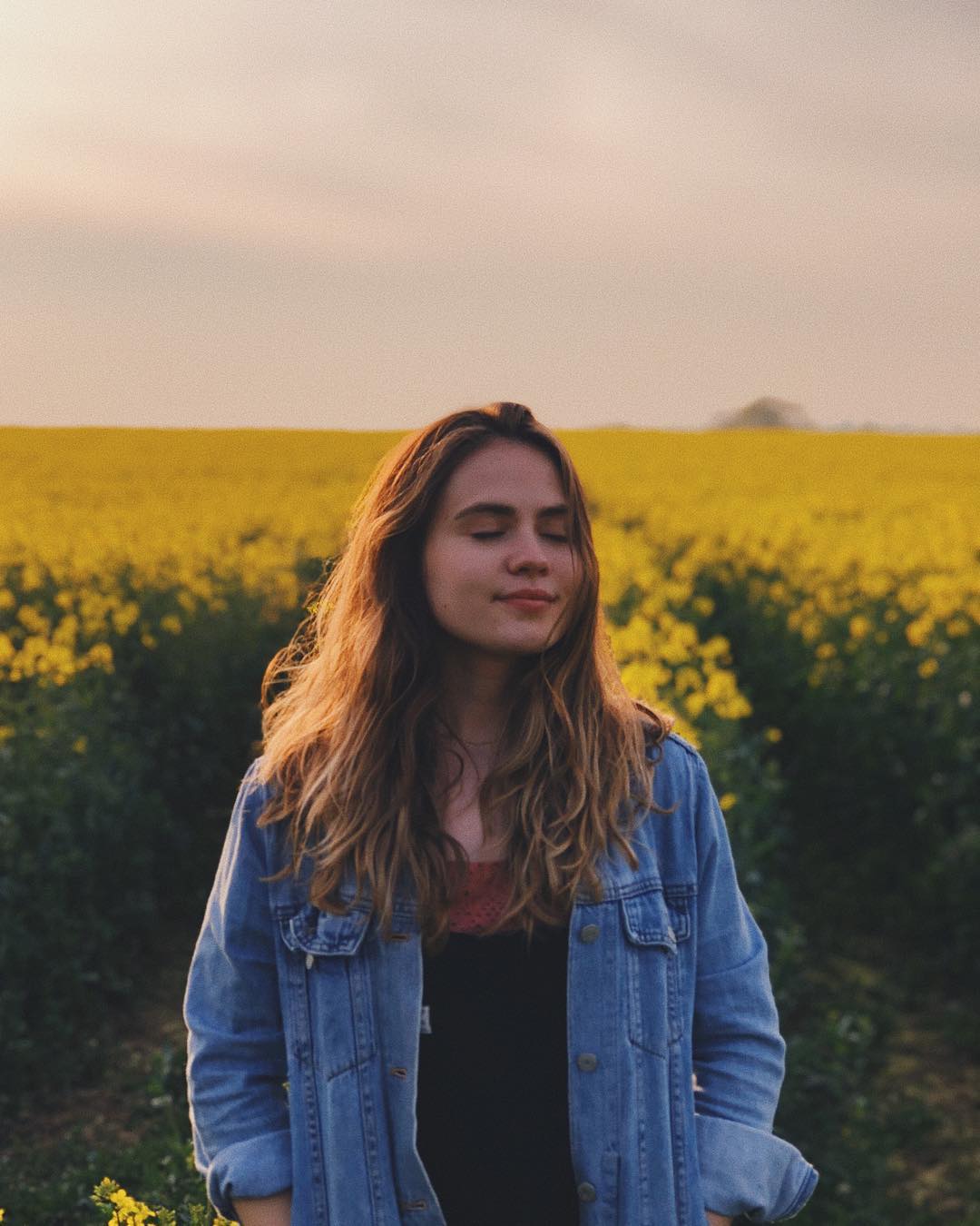 A girl stood in a field of flowers