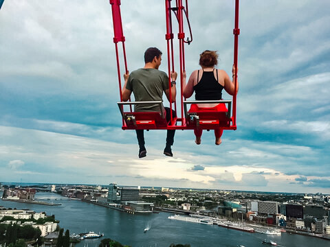 Two people swing over the city