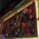 Photo of lots of different types and brands of guitars hung on the wall.
