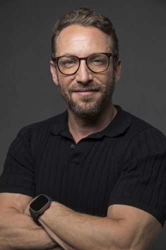 Headshot of a man with his arms crossed.